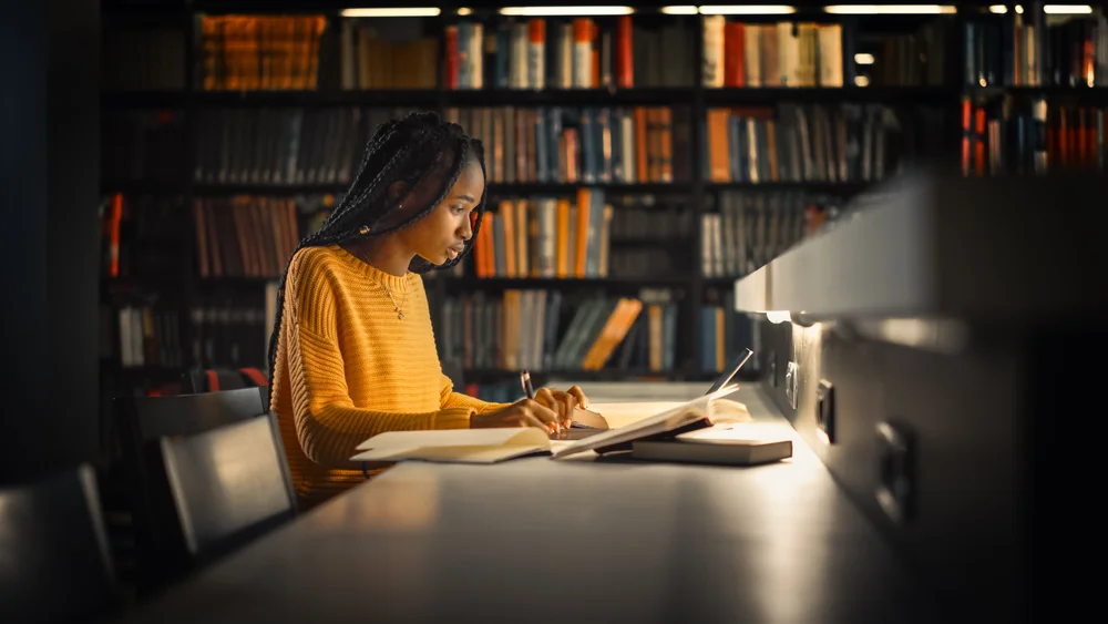 Gifted Black Girl uses Laptop, Writes Notes for the Paper